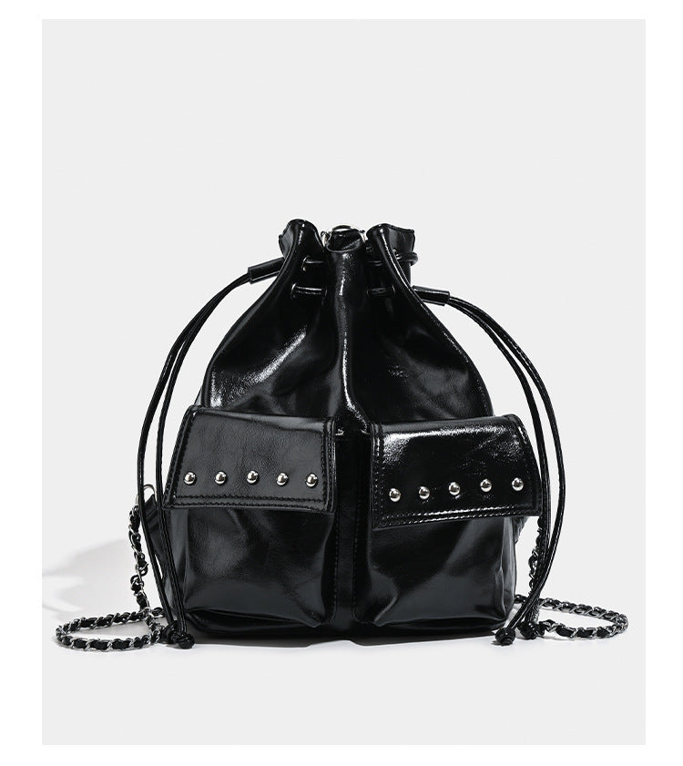 Glossy leather-look drawstring bucket bag with silver dome studs and chain shoulder strap, detail view 10