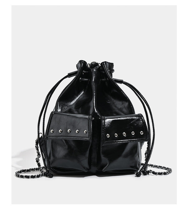 Glossy leather-look drawstring bucket bag with silver dome studs and chain shoulder strap, detail view 10
