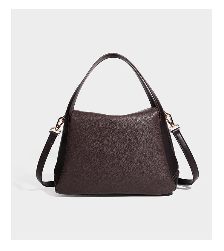 Structured pebbled leather-look shoulder bag with flap top, gold-tone emblem hardware, dual top handles, and detachable