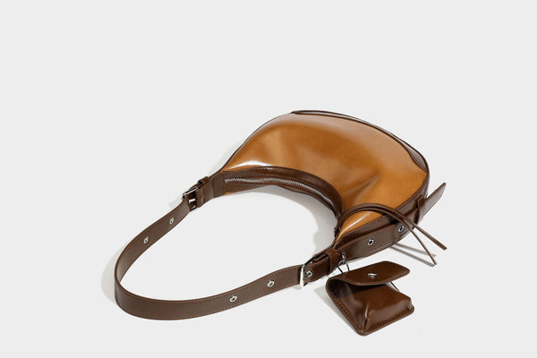 Glossy leather-look crescent hobo shoulder bag with dark contrast trim, silver-tone hardware, and attached mini flap pouch