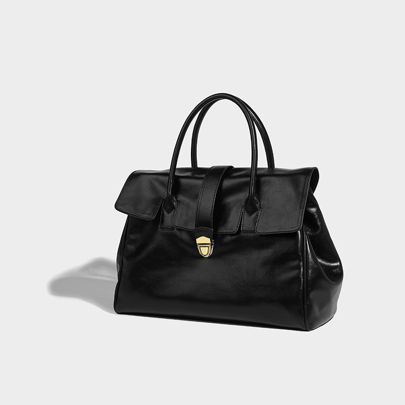 Strukturierte Henkeltasche im Shopper-Stil aus glänzender Lederoptik mit Überschlag, Mittelriemen, goldfarbenem Drehverschluss und zwei Henkeln