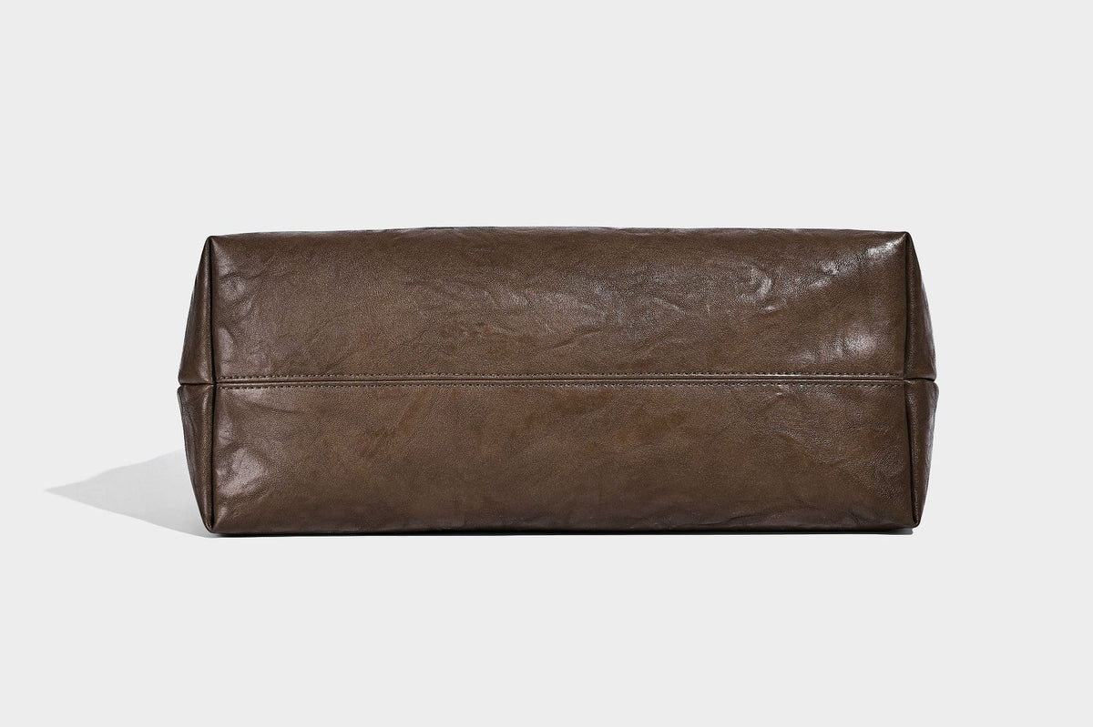 Large open-top tote bag with crinkled leather-look finish, long double shoulder straps, and embossed circular detail on