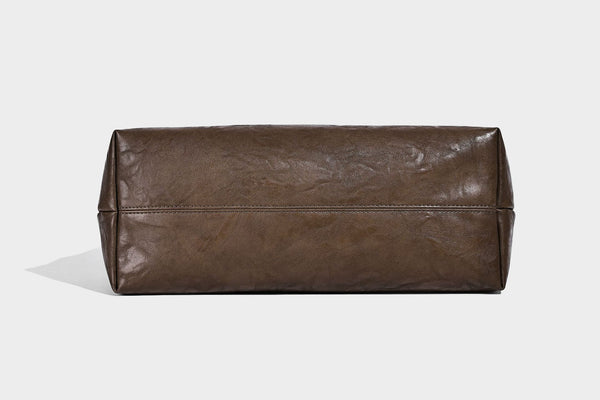 Large open-top tote bag with crinkled leather-look finish, long double shoulder straps, and embossed circular detail on