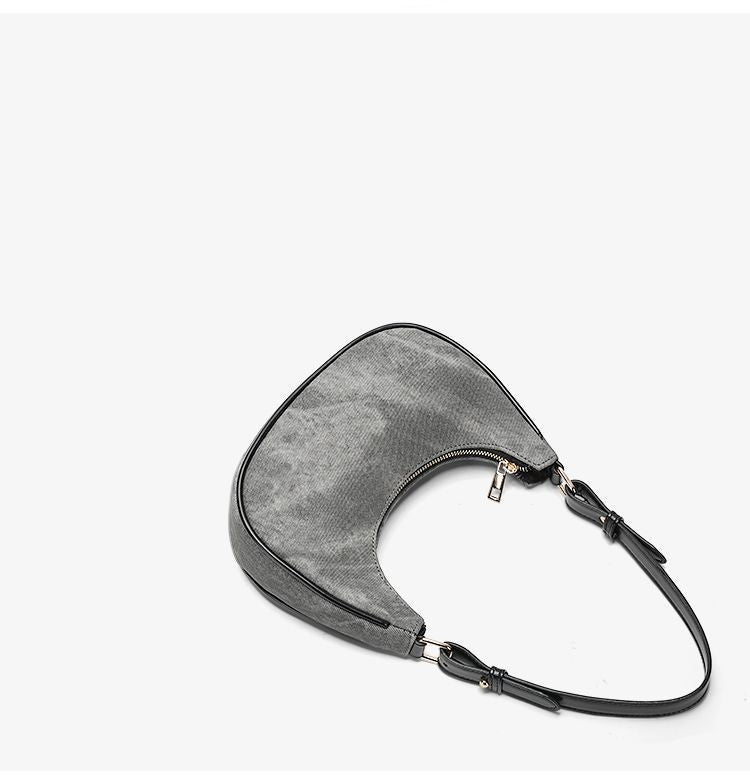 Small gray crescent half-moon shoulder bag with black leather-look trim, gold-tone zipper, and adjustable slim strap, detail
