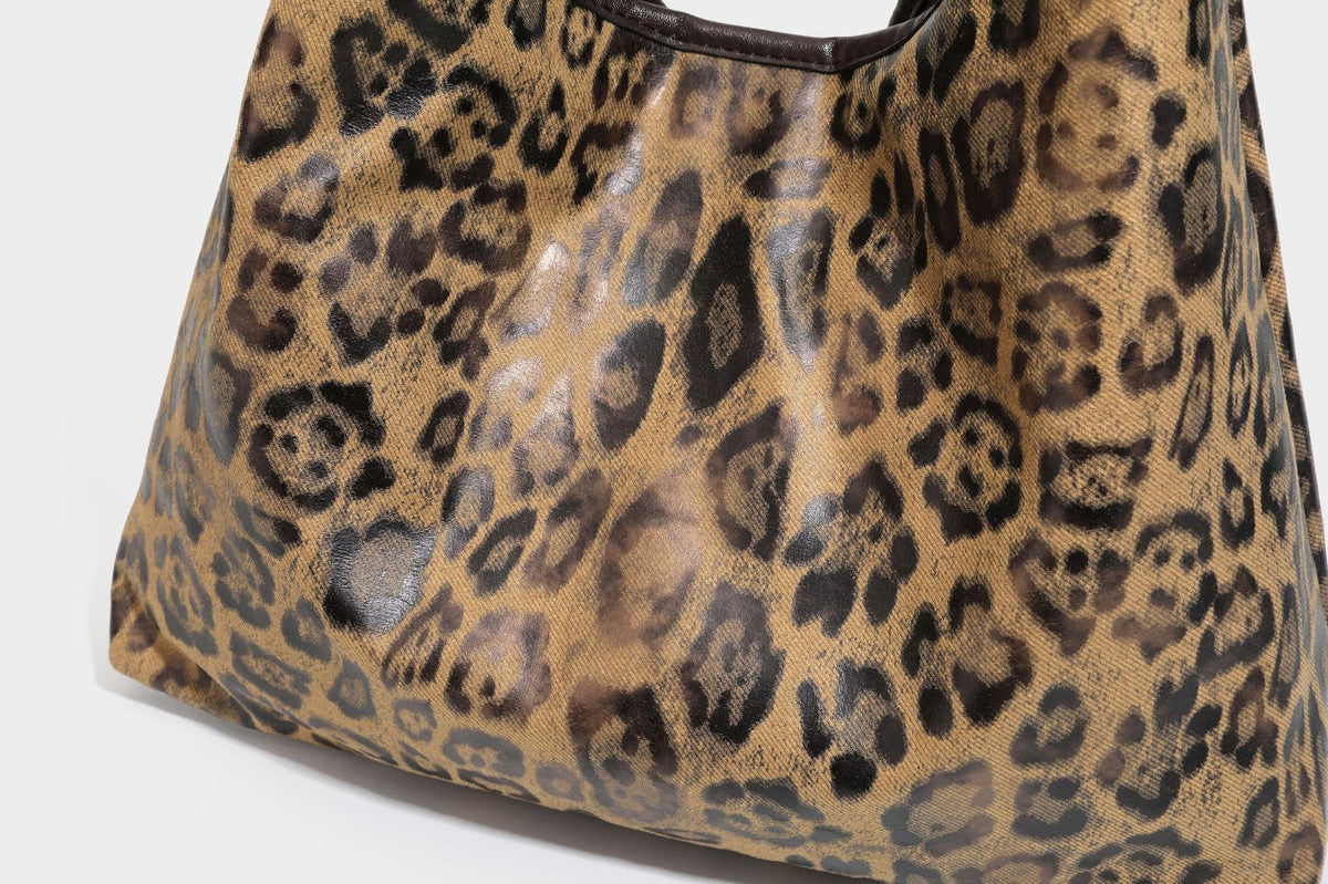 Weich fallende Hobo-Tote-Bag mit Leopardenmuster in Beige und Braun, dunkelbraunem Riemen in Lederoptik und herabhängenden Perlenanhänger-Beschlägen