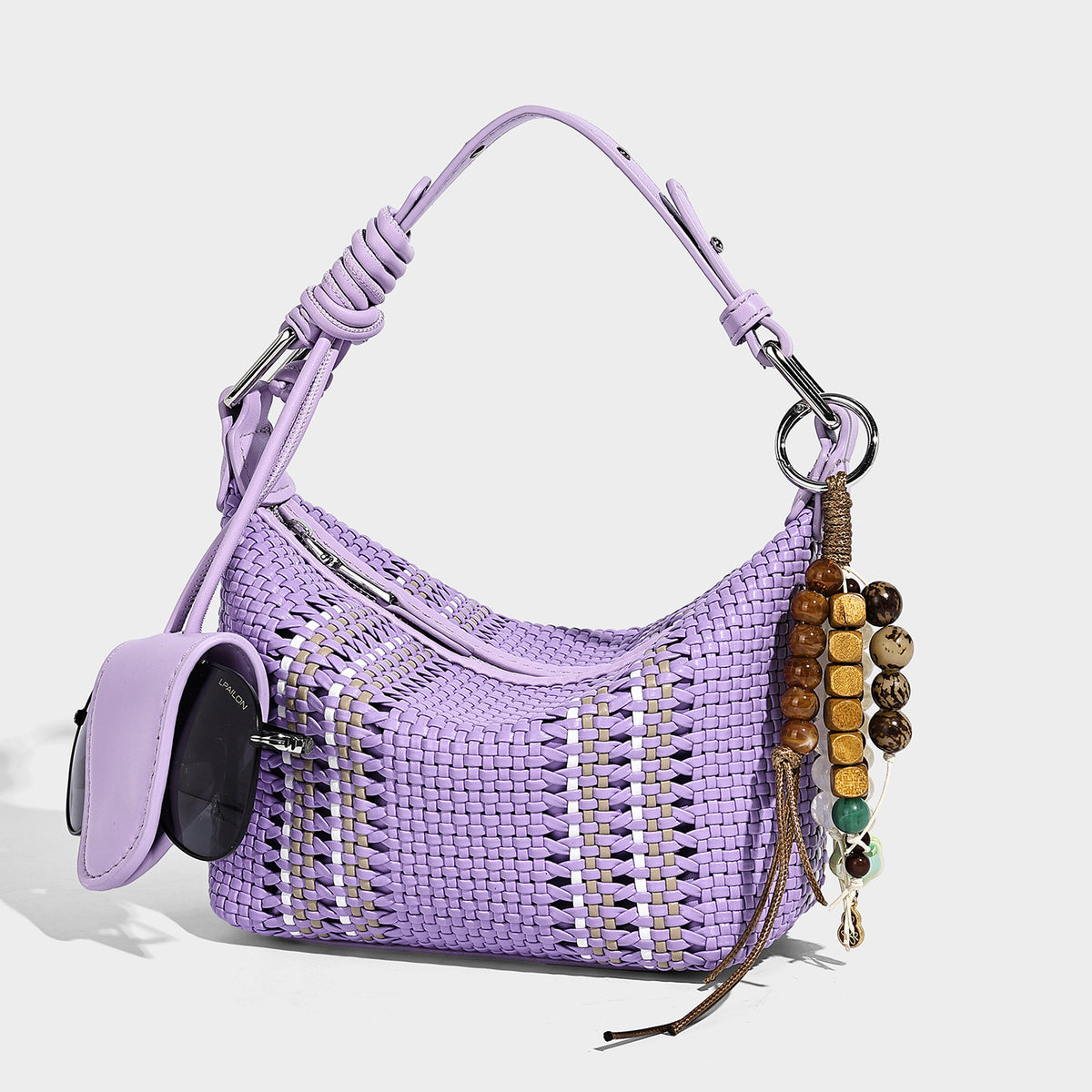 Small woven crescent shoulder bag with leather-look trim, zip closure, silver-tone ring hardware, and beaded tassel charm