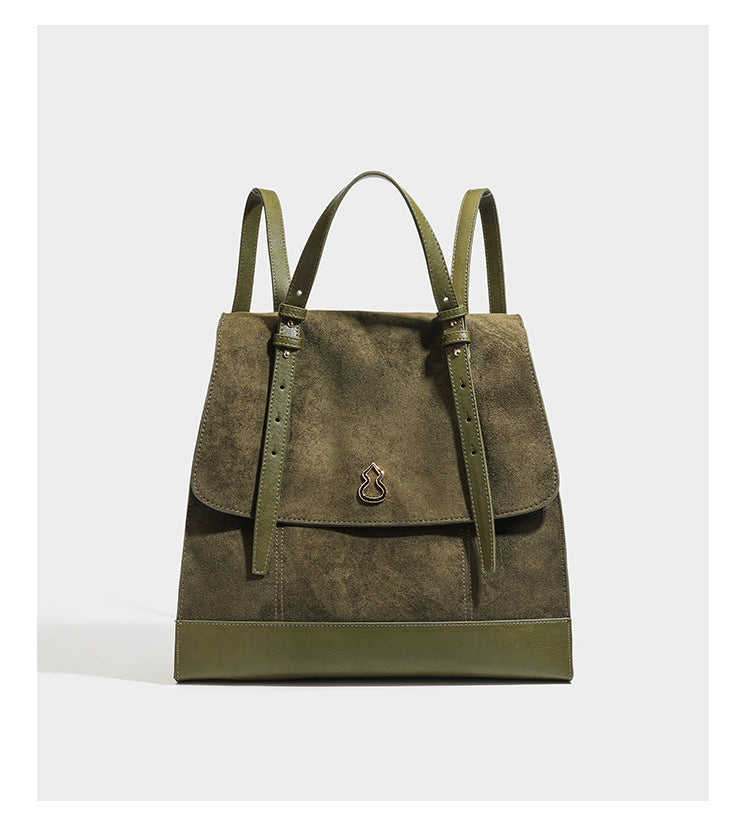 Structured suede-look convertible backpack handbag with flap closure and gold-tone emblem hardware in chocolate brown, detail