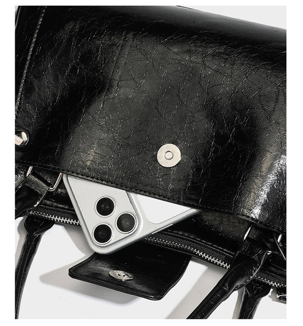 Structured glossy crinkled leather-look satchel with double top handles, front metal-plaque tab, silver-tone hardware, and