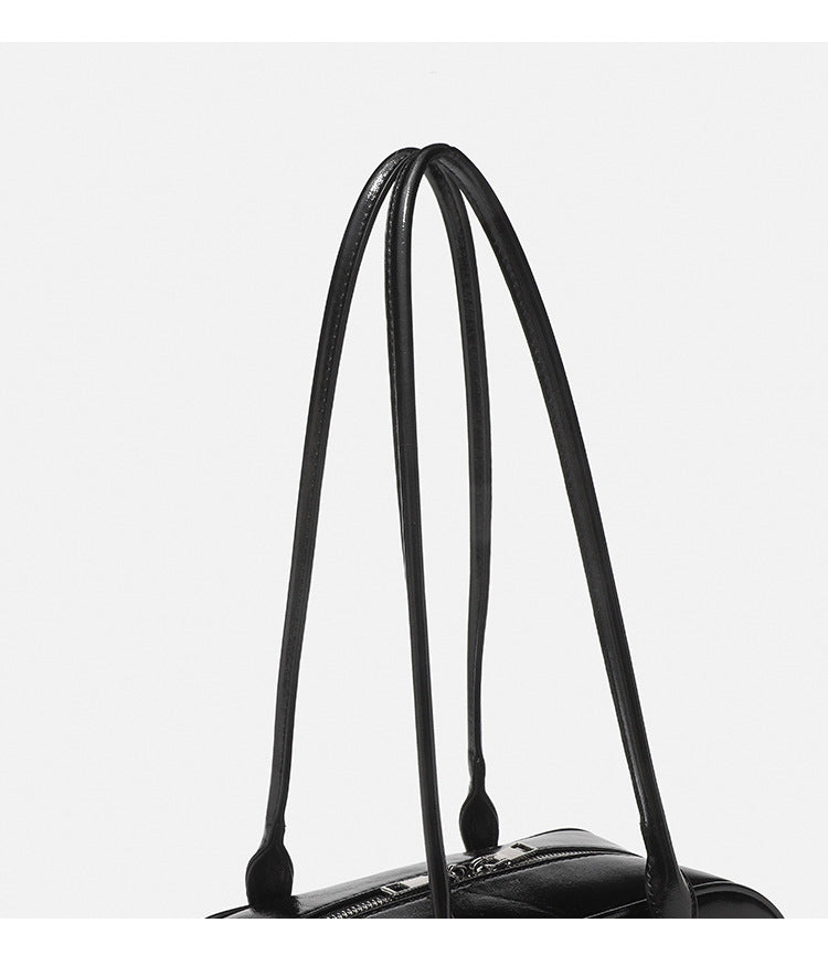 Structured glossy leather-look bowling shoulder bag with two front flap pockets, top zip closure, and long double shoulder