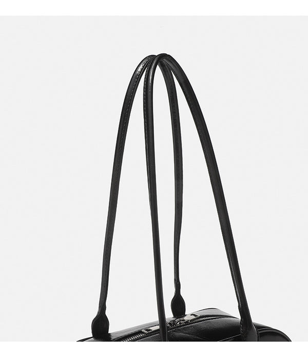Structured glossy leather-look bowling shoulder bag with two front flap pockets, top zip closure, and long double shoulder