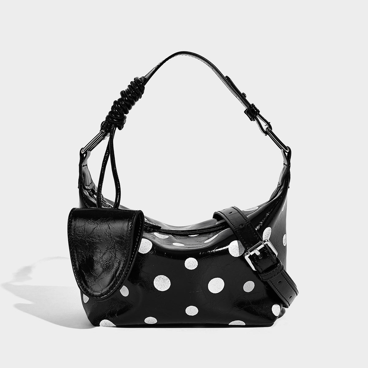 Gepunktete Schultertasche in glänzender Lederoptik mit befestigtem Mini-Fronttäschchen, Reißverschluss oben und verstellbarem Riemen, Detailansicht