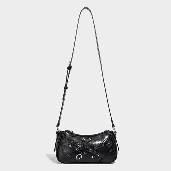 Compact moto-inspired shoulder bag with crisscross grommet strap detail, glossy textured finish, and adjustable crossbody