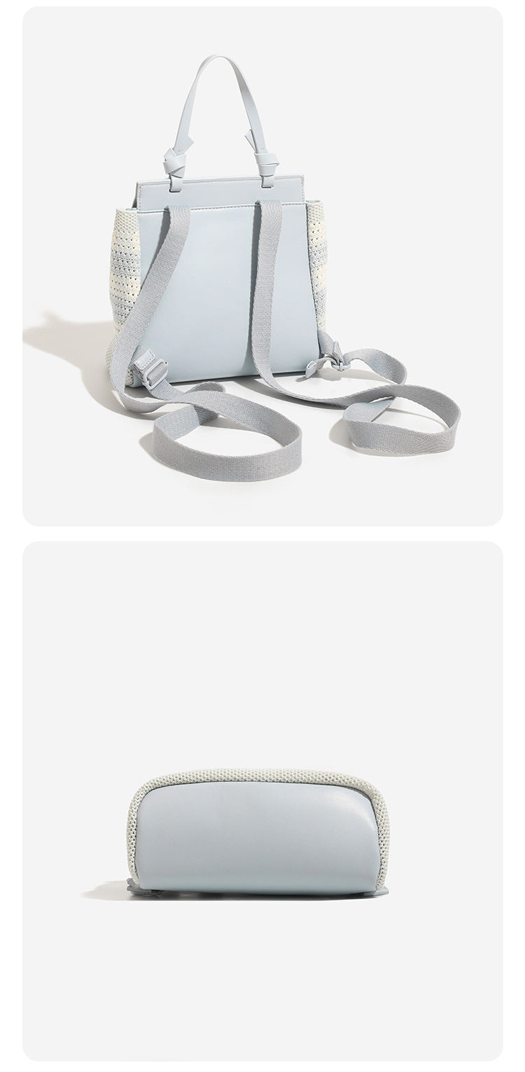 Small structured woven-body flap bag with smooth leather-look front panel, knotted top handle, and wide adjustable shoulder