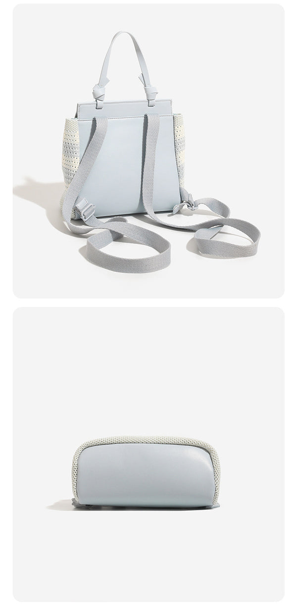 Small structured woven-body flap bag with smooth leather-look front panel, knotted top handle, and wide adjustable shoulder