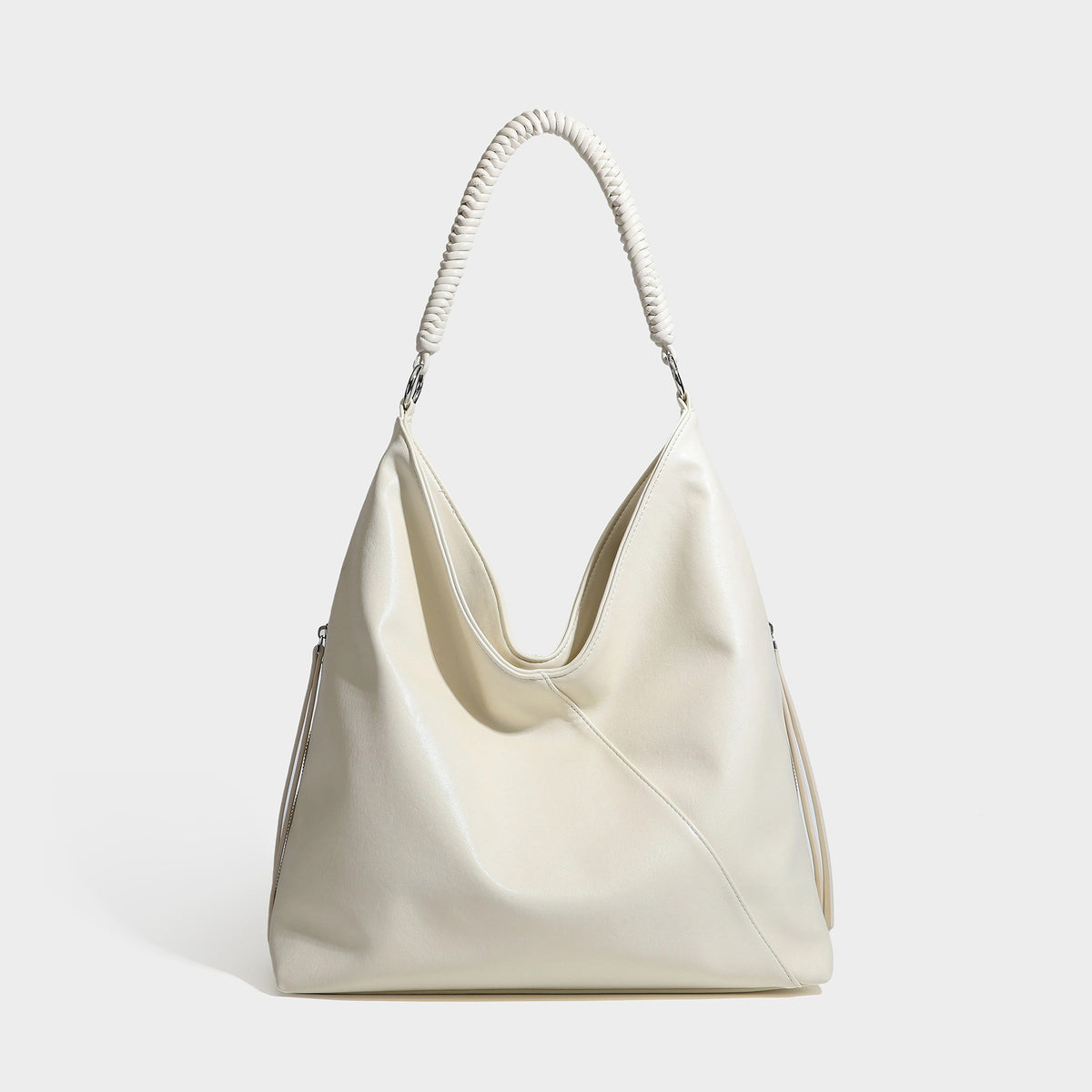 Large slouchy hobo shoulder bag with braided top handle, smooth glossy leather-look finish, and silver-tone ring hardware