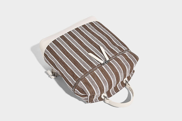 Small structured striped fabric backpack handbag with cream leather-look trim, top handle, and silver-tone hardware, detail