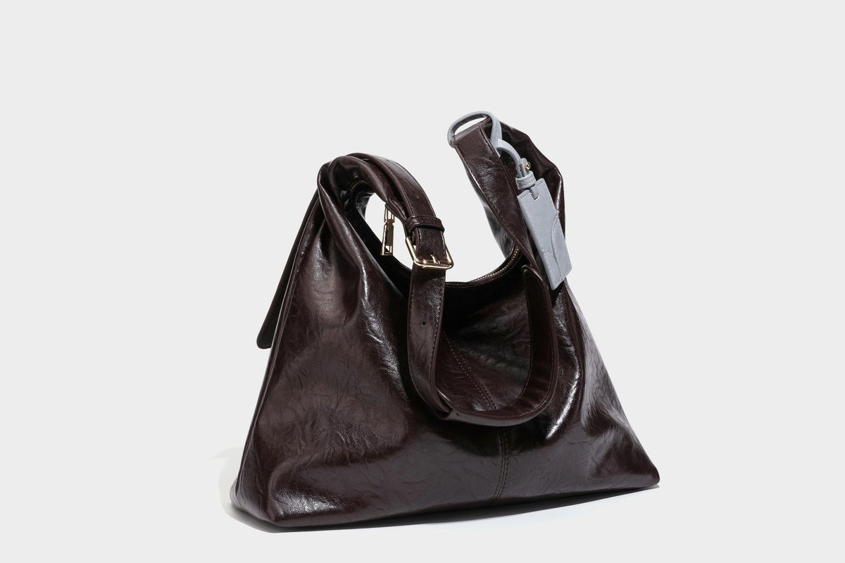 Große dunkelbraune, glänzende, geknautschte Hobo-Schultertasche mit Reißverschluss, goldfarbenen Metalldetails, verstellbarem Trageriemen und Hellblau