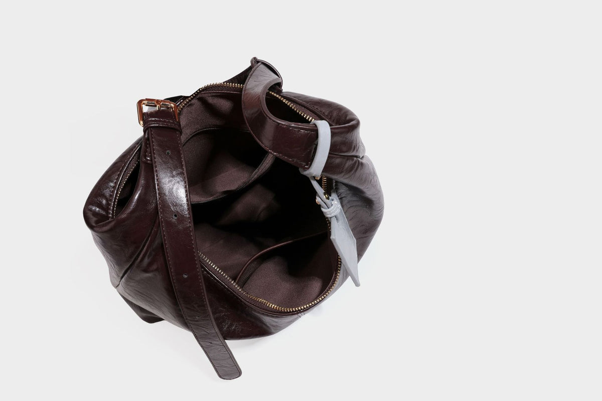 Große dunkelbraune, glänzende, geknautschte Hobo-Schultertasche mit Reißverschluss, goldfarbenen Metalldetails, verstellbarem Trageriemen und Hellblau