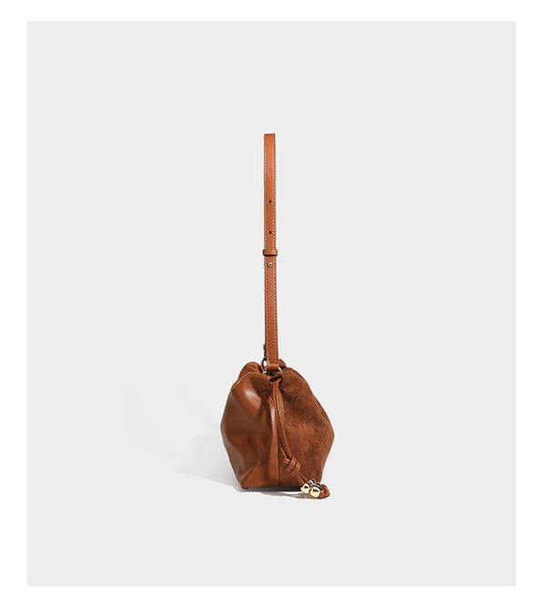 Suede-look drawstring shoulder bag in brown with smooth trim, knotted bead drawstring closure, slim adjustable strap, and