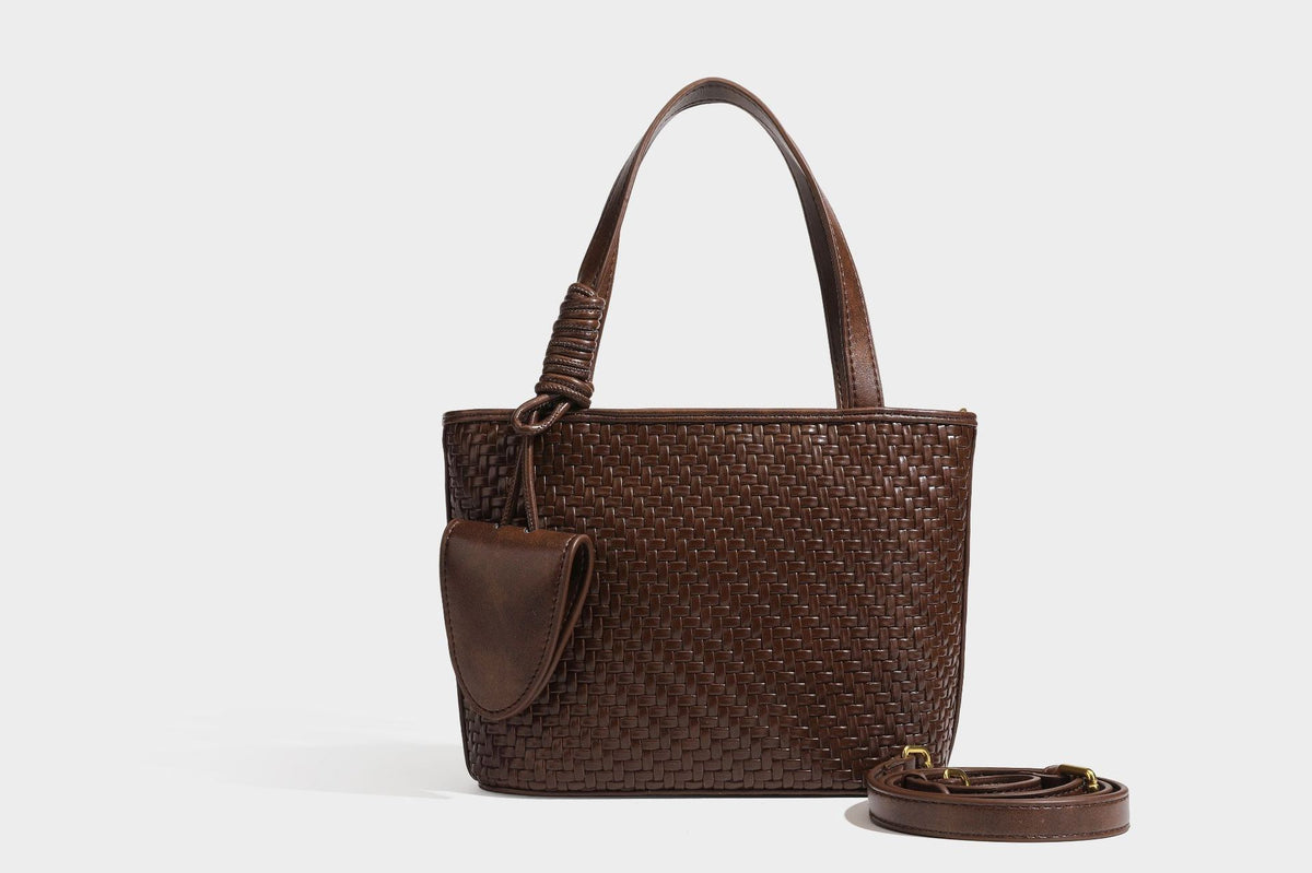 Strukturierte Tote Bag mit gewebter Oberfläche in Braun, goldfarbenen Metalldetails, seilumwickelten Tragegriffen, einer kleinen Fronttasche und weiteren Details