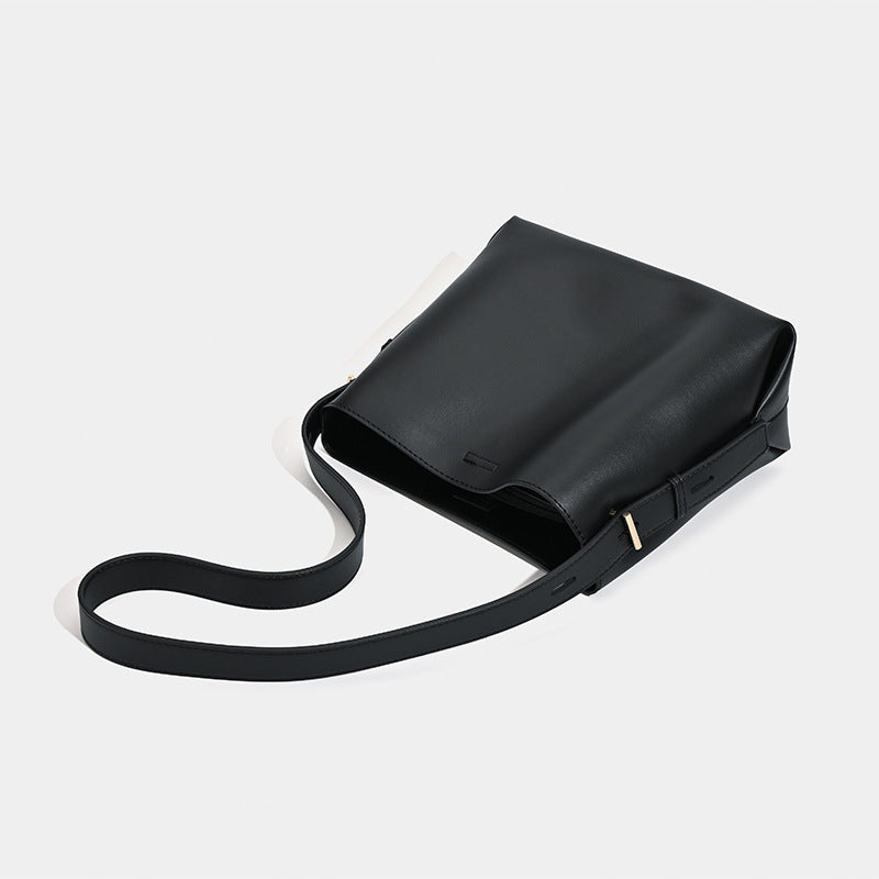 Große schwarze Bucket Bag mit glatter, matter Lederoptik, goldfarbenen Metalldetails und langem Schulterriemen