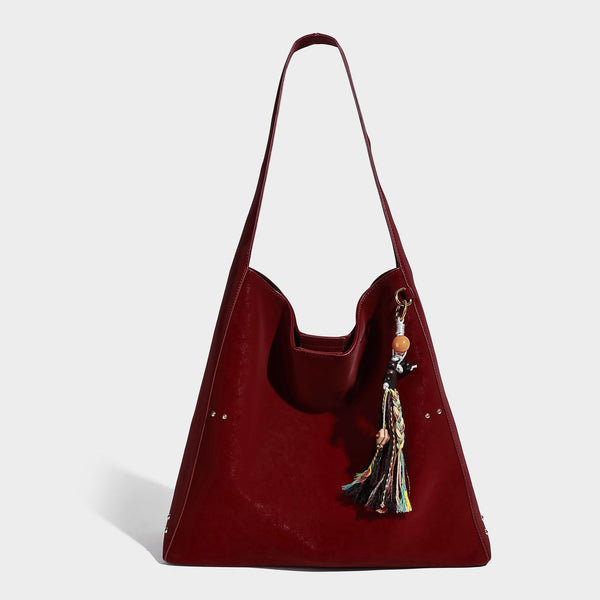 Oversized trapezoid tote bag with matte leather-look finish, gold-tone rivets, and long shoulder strap, detail view 8