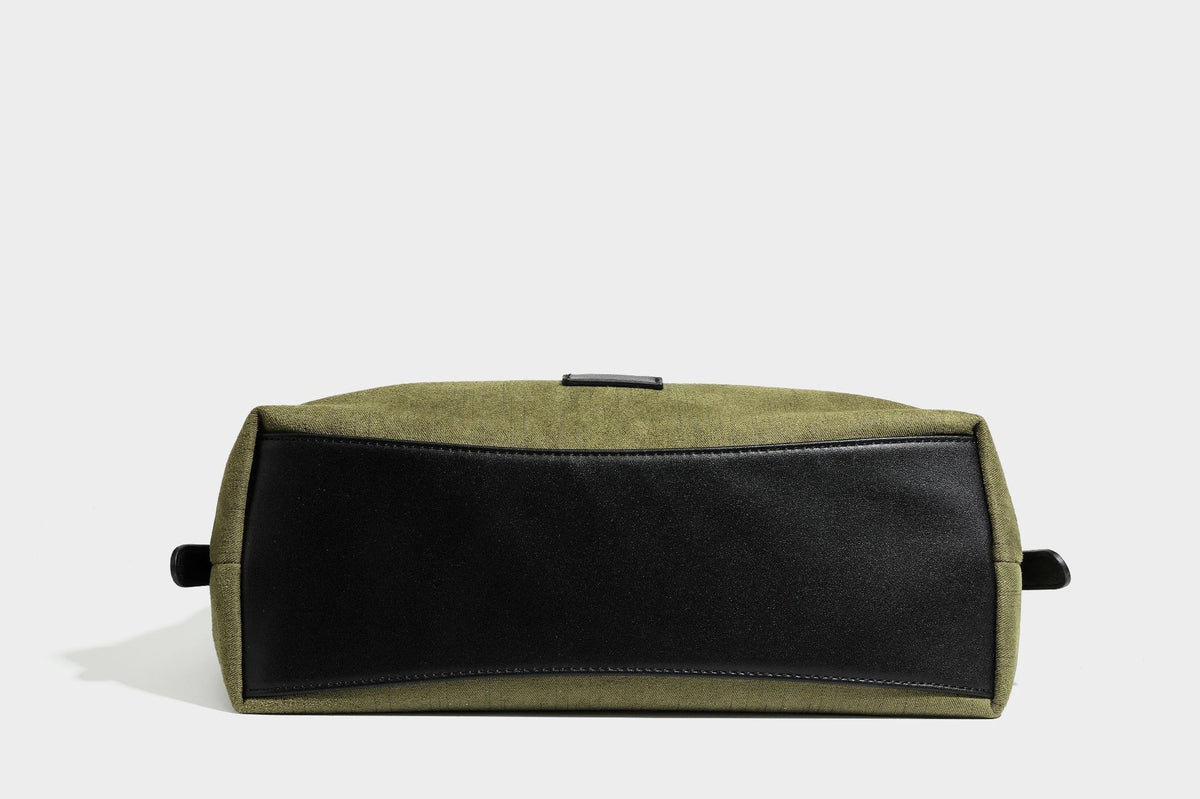 Slouchy olive green canvas hobo shoulder bag with black leather-look trim, zip-top closure, and adjustable strap, detail view