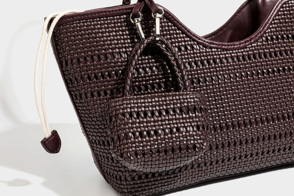 Tote-Bag aus strukturiertem Webmaterial in Dunkelbraun mit geflochtenen Henkeln, seitlichen Kordelzügen und einem befestigten Mini-Beutel aus Webmaterial mit