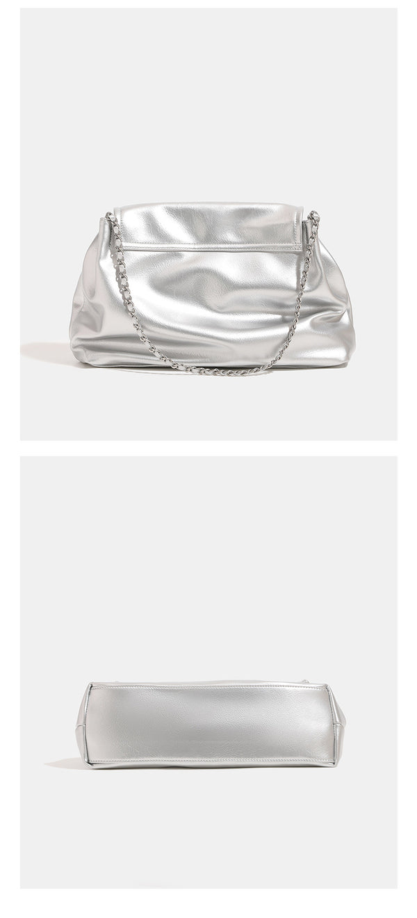 Soft trapezoidal chain-strap shoulder bag with foldover flap and circular logo medallion, detail view 9