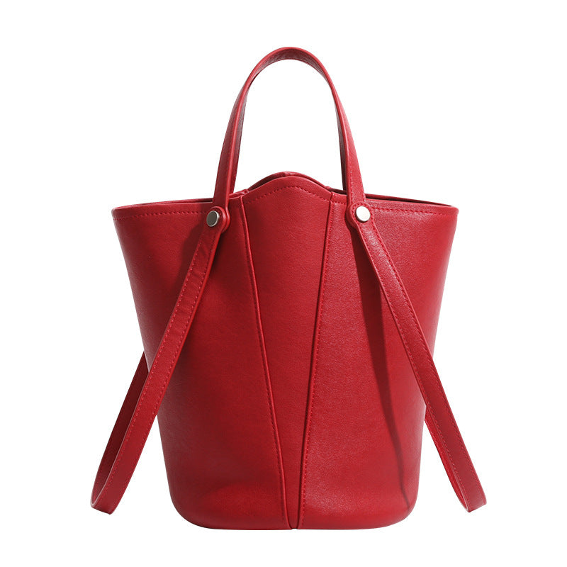 Large leather-look bucket tote bag with dual top handles and adjustable crossbody strap, detail view 5