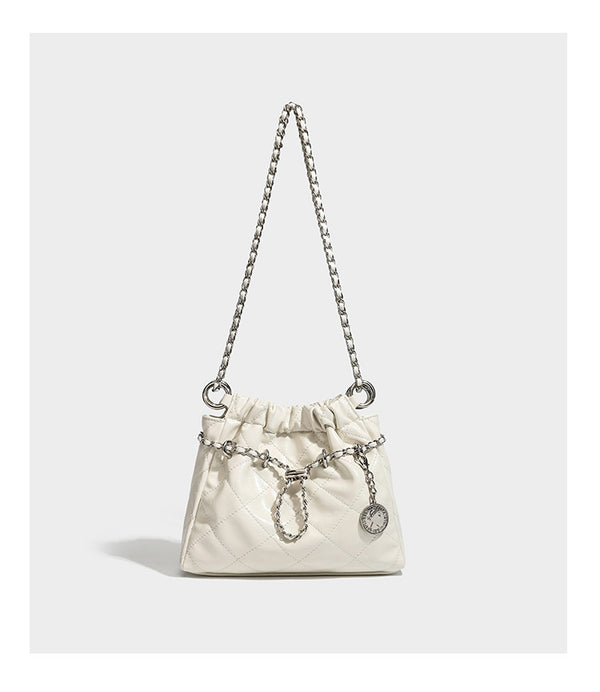 Glossy diamond-quilted drawstring bucket bag with silver chain shoulder strap and medallion charm, detail view 15