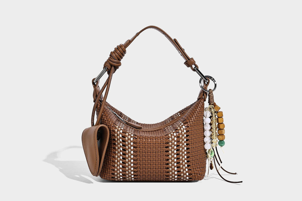 Small woven crescent shoulder bag with leather-look trim, zip closure, silver-tone ring hardware, and beaded tassel charm
