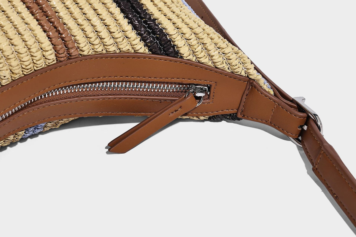 Slouchy woven straw hobo shoulder bag with beige, black, brown, and blue vertical stripes and brown leather-look trim, detail
