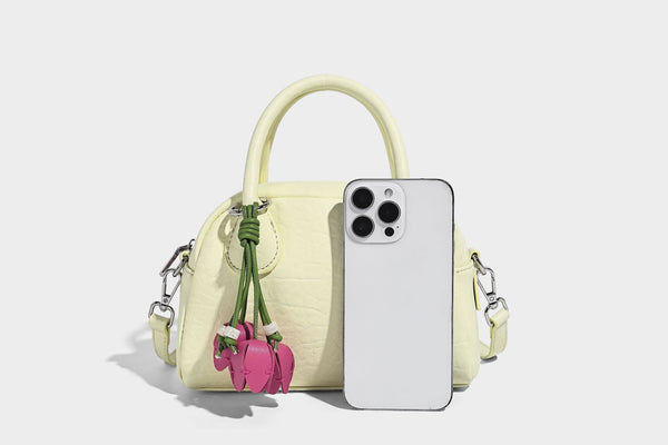 Mini-Henkeltasche in strukturierter Kuppelform in Pastellgelb mit genarbter Lederoptik, silberfarbenen Beschlägen und abnehmbarem