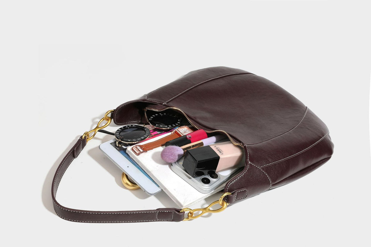 Lässige halbmondförmige Hobo-Schultertasche in Dunkelbraun mit goldfarbenem Ring und Kettenglied-Beschlägen sowie Reißverschluss oben, Detailansicht