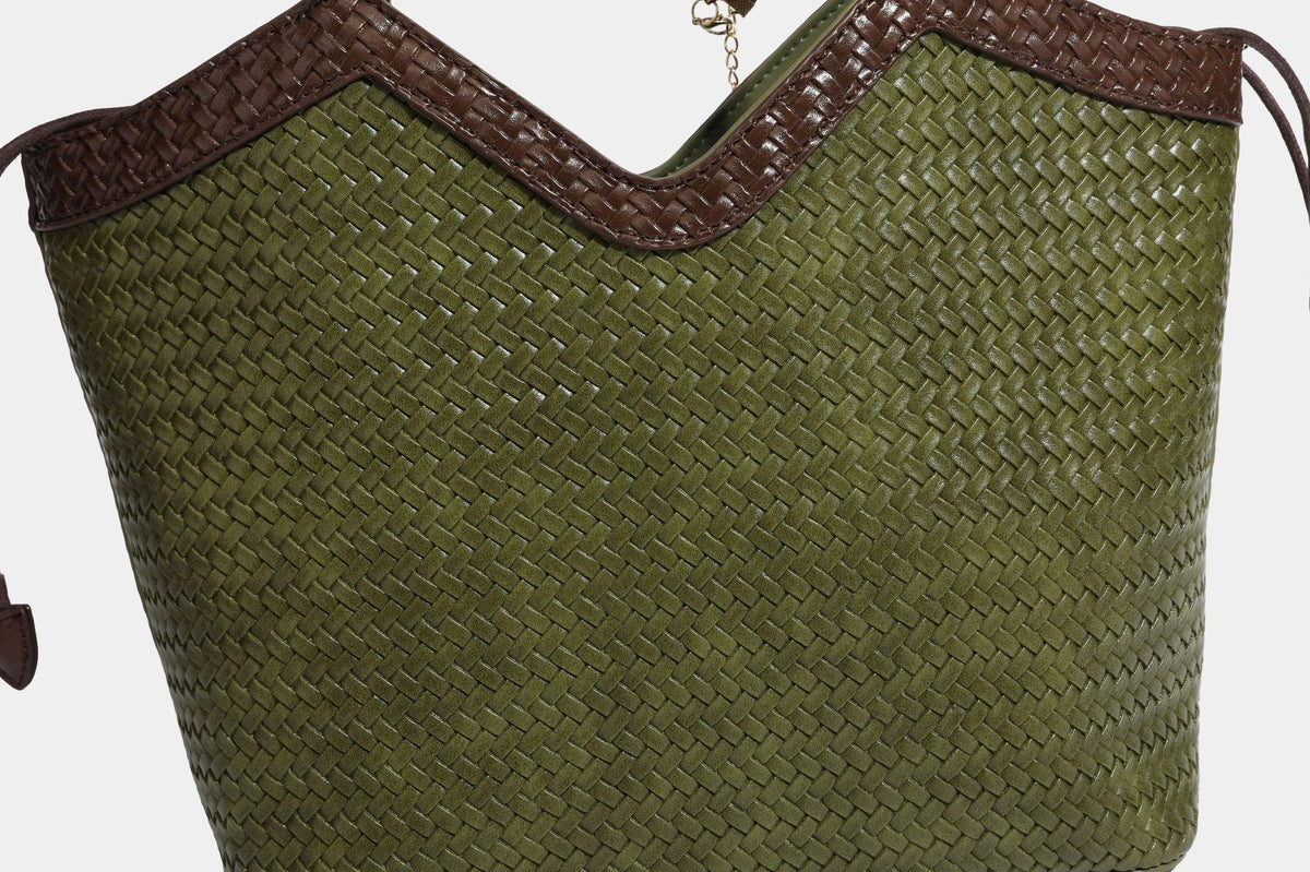 Olivgrüne Tote-Bag in Korbgeflecht-Optik mit dunkelbraunen geflochtenen Schulterriemen, seitlichen Kordelzügen und Perlenanhänger in Goldoptik