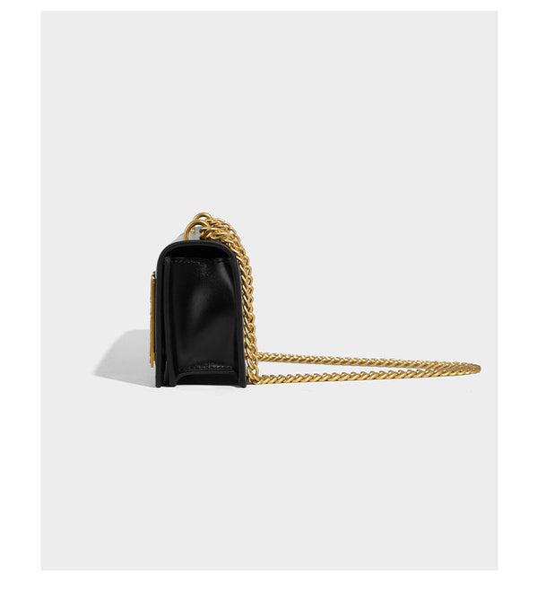 Structured rectangular crossbody bag with glossy finish, three vertical gold-tone embossed plaques, and gold chain strap