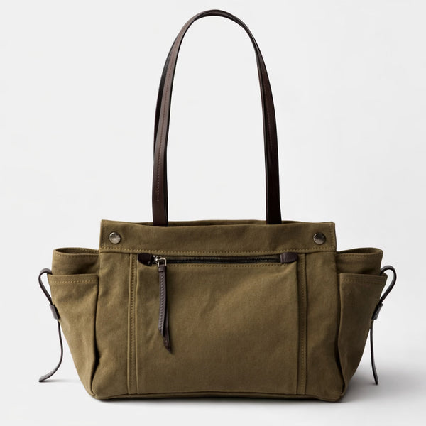 Large olive canvas shoulder tote bag with multiple front buckle-strap pockets and dark brown leather-look trim, detail view