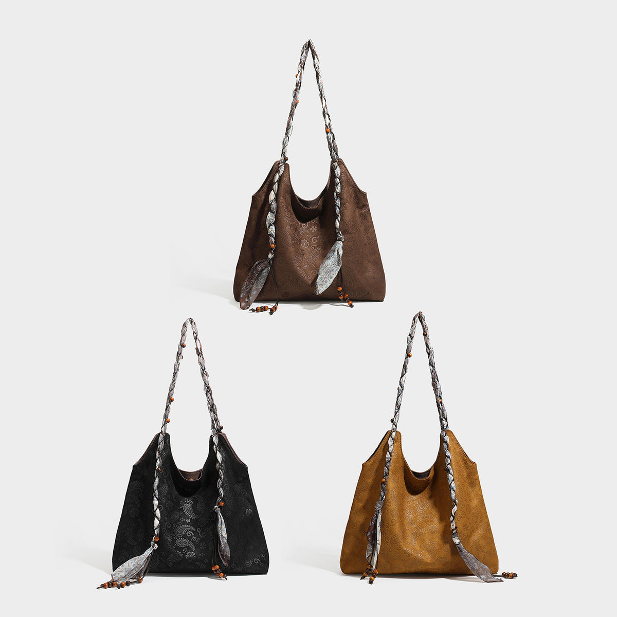 Slouchy paisley-embossed suede-look shoulder tote bag with braided patterned fabric straps and wood bead accents, detail view