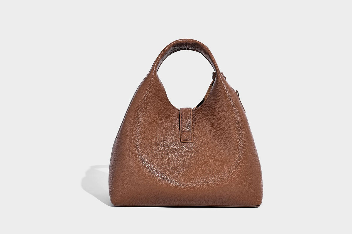 Structured pebbled-texture bucket bag with arched top handles, gold-tone turn-lock closure, and detachable shoulder strap