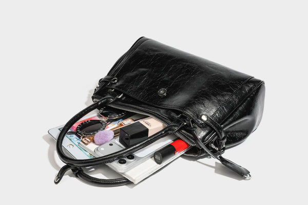 Structured glossy crinkled leather-look satchel with double top handles, front metal-plaque tab, silver-tone hardware, and