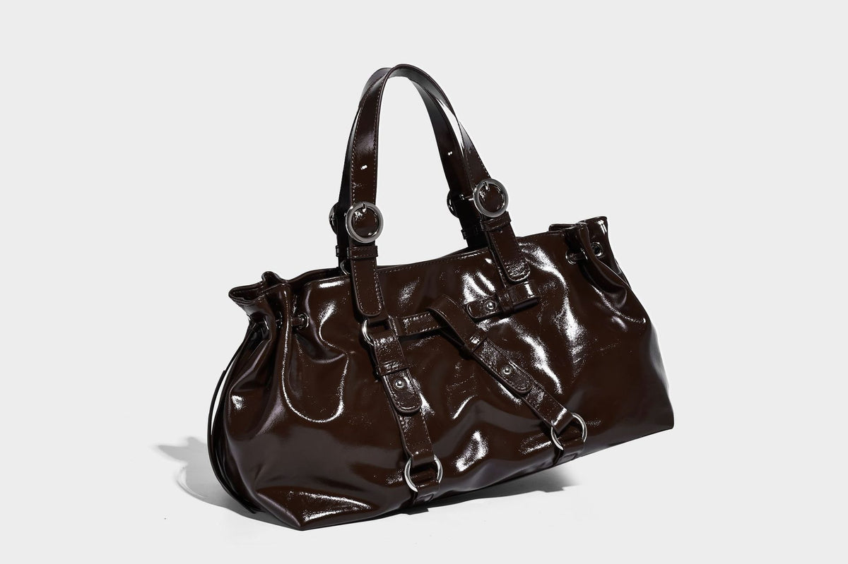 Glossy patent-look slouchy tote bag with ruched drawstring sides, dual top handles, silver ring hardware, and detachable