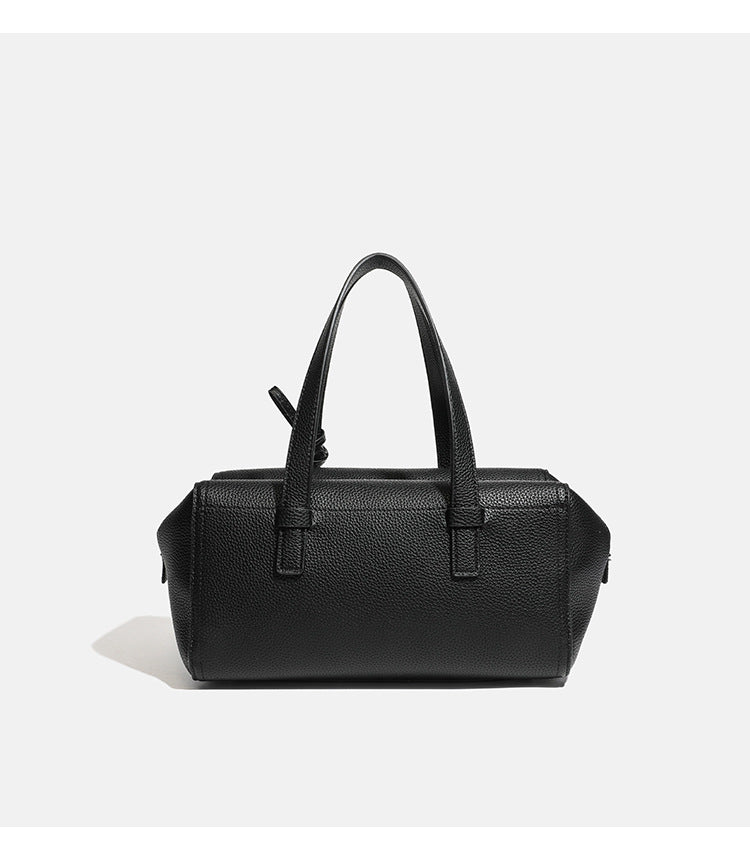 Structured pebbled leather-look top-zip barrel bag with dual handles, detachable shoulder strap, and attached croc-pattern