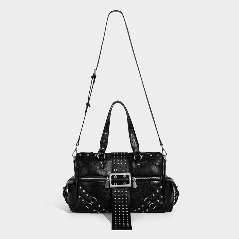 Black glossy pebbled-texture satchel bag with silver studs, buckle strap detail, dual top handles, and wide studded shoulder