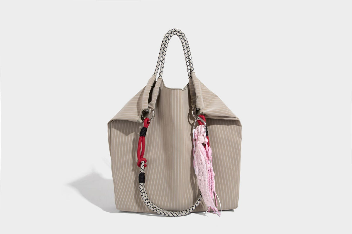 Slouchy pinstripe tote bag with braided rope handles, metal ring hardware, and colorful knotted rope charm, detail view 37