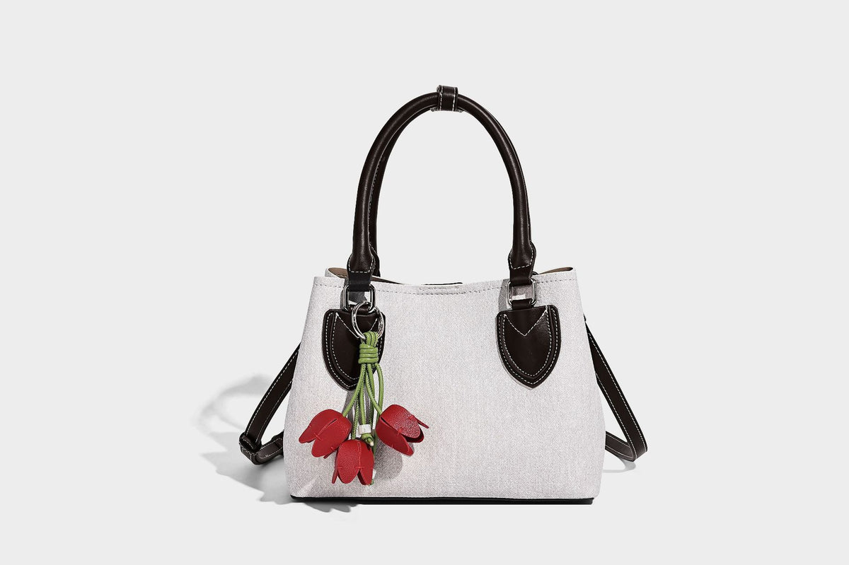 Structured light-blue denim-look tote bag with black leather-look handles, white contrast stitching, silver-tone hardware