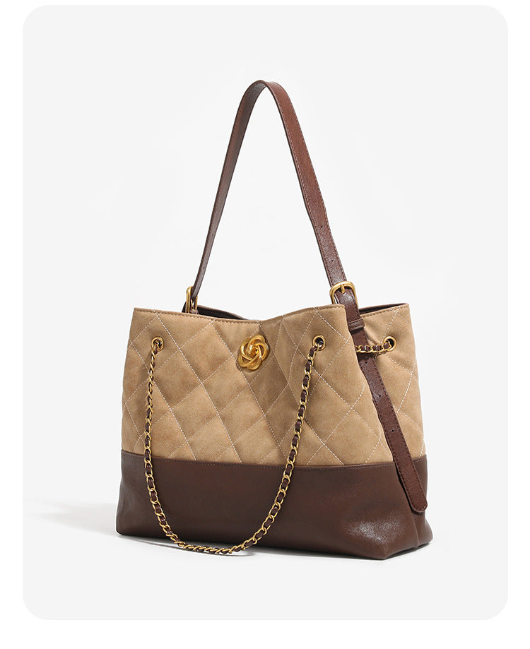 Two-tone tan quilted and dark brown leather-look tote bag with gold chain strap and floral knot emblem, detail view 7
