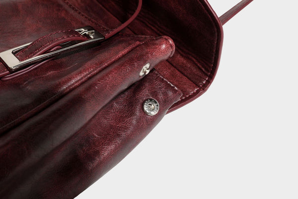 Structured flap-top shoulder tote bag in distressed leather-look finish with silver-tone buckle hardware and double shoulder