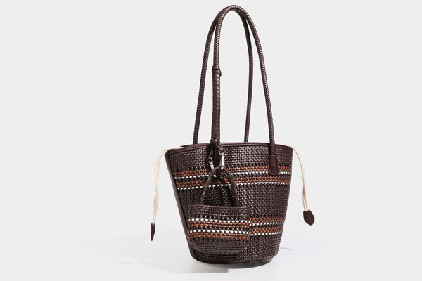 Light blue open-weave woven bucket tote bag with long braided shoulder straps, drawstring side ties, and attached mini pouch
