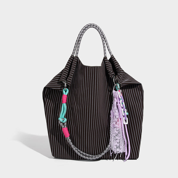 Slouchy pinstripe tote bag with braided rope handles, metal ring hardware, and colorful knotted rope charm, detail view 8